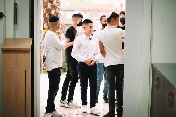 נער העולה לתורה עם חבריו בכניסה לבית הכנסת