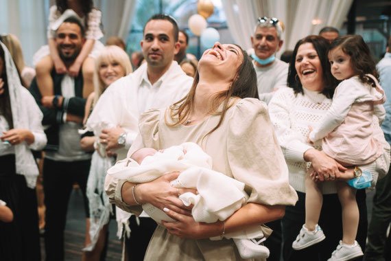 דודה מגישה את התינוק תוך כדי הצחוק | צילום ברית מילה