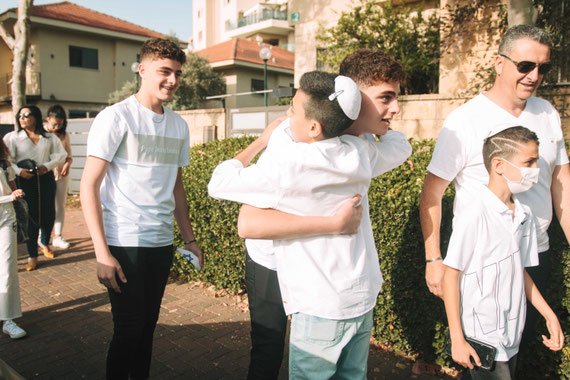 נועם פוגש את האורחים ליד האוטובוס | בר מצווה בכותל יוצאת אל הדרך