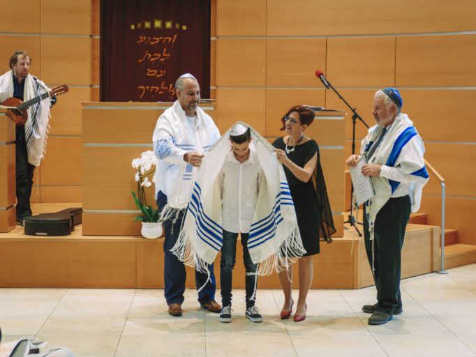 אמא ואבא מכסים את החתן בתלית - בית הכנסת הרפורמי דרכי נועם